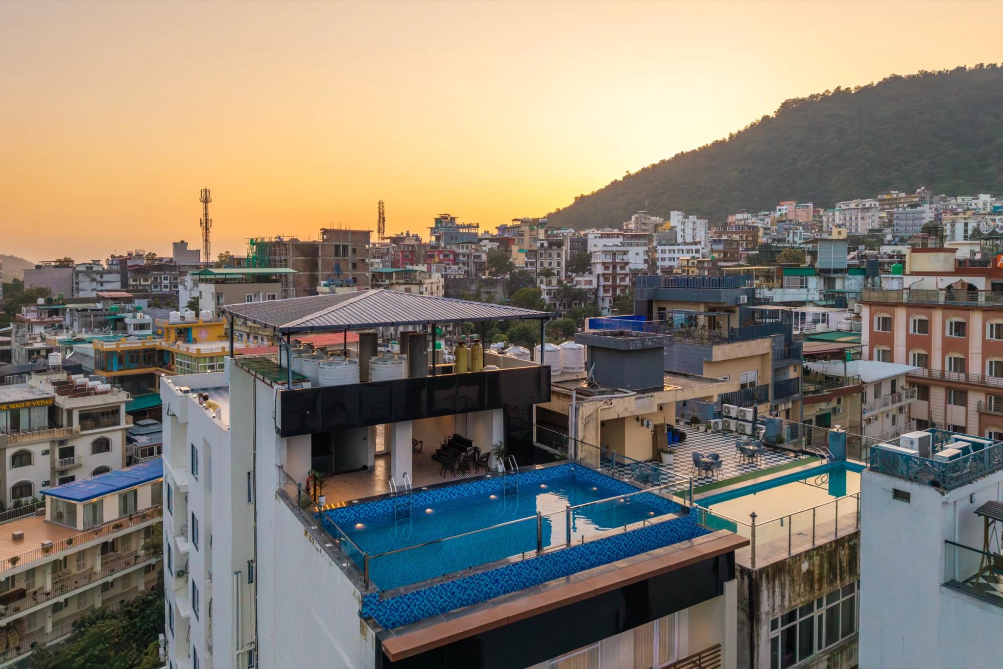 Aerial view of FRAZ Rishikesh and its rooftop pool at sunset