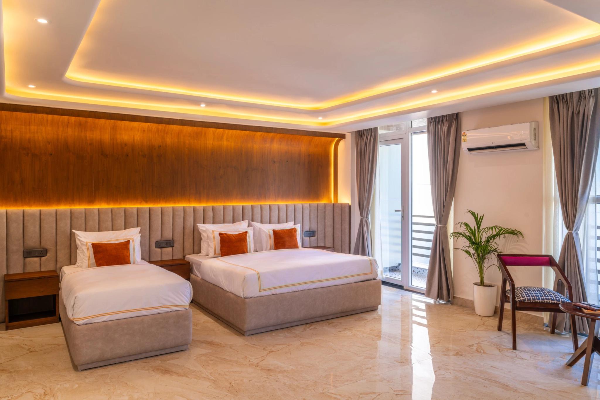 Private suite with a warm-lit walnut wall and crisp white beds