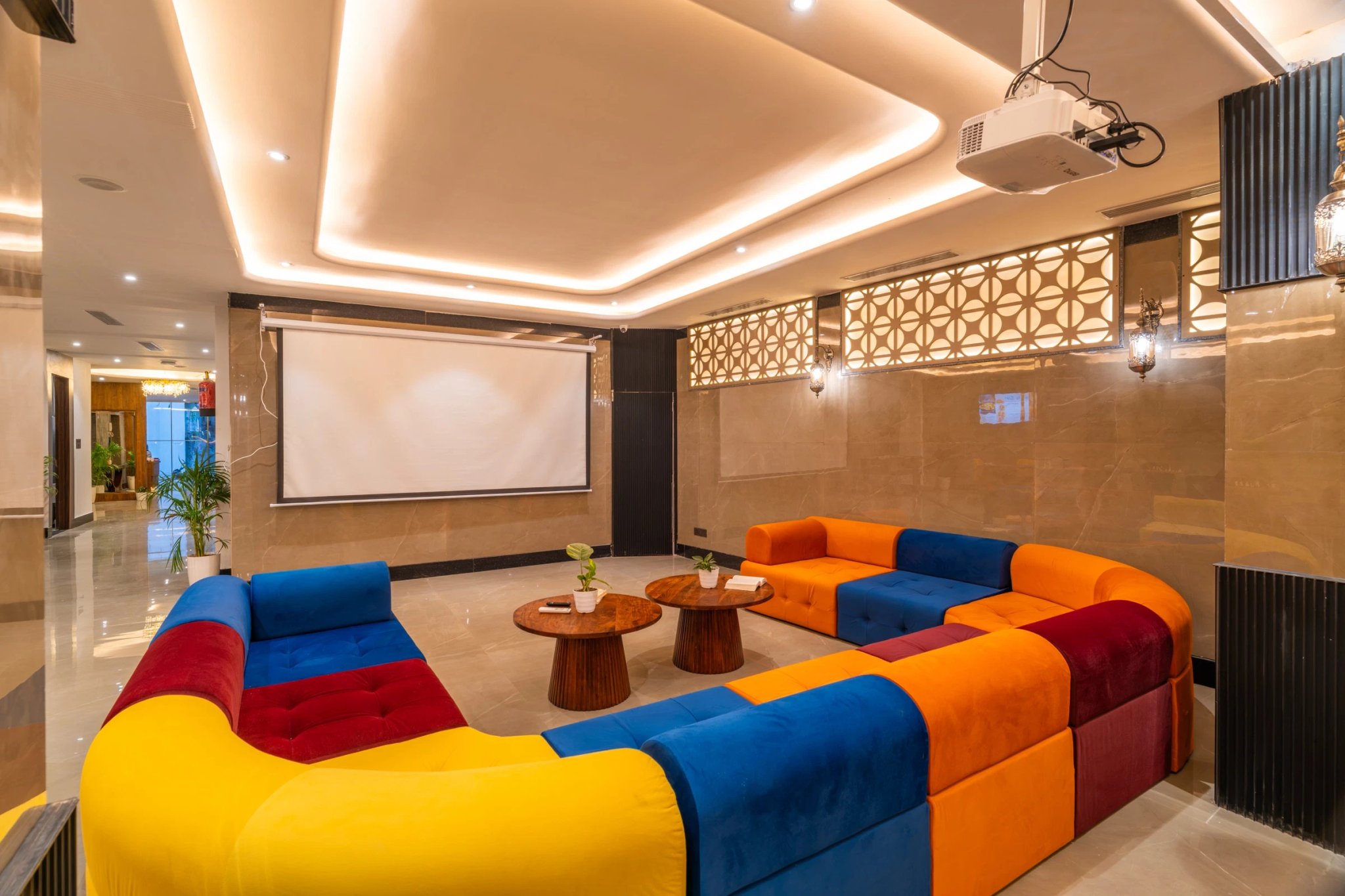 Colour-blocked sofas facing the projector screen in the lounge